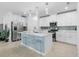 Bright, modern kitchen with white cabinetry, stainless steel appliances, and a stylish island at 17222 Holly Well Ave, Wimauma, FL 33598