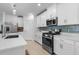 Modern kitchen with white cabinets, a large island, stainless steel appliances, and tile backsplash at 17222 Holly Well Ave, Wimauma, FL 33598