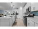 Open-concept kitchen featuring white cabinets, a large island, and stainless steel appliances at 17222 Holly Well Ave, Wimauma, FL 33598