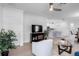 Cozy living room leading into a modern kitchen, creating an inviting open-concept living space at 17222 Holly Well Ave, Wimauma, FL 33598