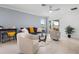 Comfortable living room featuring tile floors, a ceiling fan, and access to the patio at 17222 Holly Well Ave, Wimauma, FL 33598