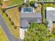 Aerial view of home showcasing a screened pool, lush yard, and grey roof at 1851 Skyland Dr, Clearwater, FL 33759