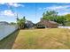 Spacious backyard featuring a screened-in pool enclosure, white fence, and well-maintained lawn at 1851 Skyland Dr, Clearwater, FL 33759