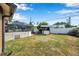 Spacious backyard with a screened-in pool area and additional covered structure at 1851 Skyland Dr, Clearwater, FL 33759