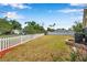 Large backyard with a white picket fence, mature trees, and ample green space at 1851 Skyland Dr, Clearwater, FL 33759