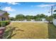 Large backyard with a white picket fence, mature trees, and ample green space at 1851 Skyland Dr, Clearwater, FL 33759
