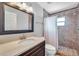 A bathroom with tile floors, large mirror and a tiled shower with glass door at 1851 Skyland Dr, Clearwater, FL 33759