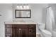 Bright bathroom featuring a dark wood vanity, sink, and toilet at 1851 Skyland Dr, Clearwater, FL 33759
