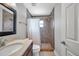 This bathroom features tile floors, updated vanity, large mirror, and a tiled shower at 1851 Skyland Dr, Clearwater, FL 33759