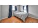 A bedroom with wood floors, neutral walls, a window with navy blue curtains at 1851 Skyland Dr, Clearwater, FL 33759
