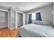 A bedroom with wood floors, neutral walls, closet with white bi-fold doors and a window at 1851 Skyland Dr, Clearwater, FL 33759
