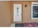 The inviting front door has a decorative glass pane and is framed by the home's exterior and well-kept landscaping at 1851 Skyland Dr, Clearwater, FL 33759