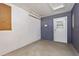 Clean garage featuring a door with window, pegboard and a fluorescent light for storage or workshop area at 1851 Skyland Dr, Clearwater, FL 33759