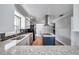 Modern kitchen featuring stainless steel appliances, white cabinets, cooktop island, and a view of the dining area at 1851 Skyland Dr, Clearwater, FL 33759
