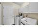 Bright laundry room with white cabinets and modern washer and dryer units at 1851 Skyland Dr, Clearwater, FL 33759