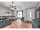 Bright living room featuring hardwood floors, a ceiling fan, and a cozy gray sectional sofa at 1851 Skyland Dr, Clearwater, FL 33759