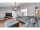 Open living room featuring hardwood floors, television, and comfortable gray sectional sofa at 1851 Skyland Dr, Clearwater, FL 33759