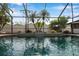 Sparkling swimming pool with waterfall feature and lush tropical landscaping, inside a screened enclosure at 1851 Skyland Dr, Clearwater, FL 33759