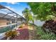 Beautiful pool area with a screened enclosure, landscaping, and vibrant foliage at 1851 Skyland Dr, Clearwater, FL 33759