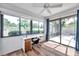 Bright sun room with large windows, wood floors, a ceiling fan, and sliding glass door to the patio at 1851 Skyland Dr, Clearwater, FL 33759