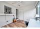 Bright sun room with wood floors, white walls, a ceiling fan, and view into kitchen at 1851 Skyland Dr, Clearwater, FL 33759