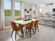 Bright dining area with modern table set, complemented by large windows and stylish decor, adjacent to the kitchen at 1877 Brekey Way, Zephyrhills, FL 33541