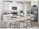 Modern kitchen featuring white cabinets, stainless steel appliances, and a granite island with stylish bar seating at 1877 Brekey Way, Zephyrhills, FL 33541