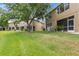 View of back of building with landscaping and lawns leading down to pond at 18939 Duquesne Dr, Tampa, FL 33647