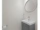 Compact bathroom with gray vanity, modern sink faucet, oval mirror, and fixtures providing practical elegance at 18939 Duquesne Dr, Tampa, FL 33647