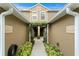 Charming home entrance with a walkway lined with manicured plants and a decorative overhead trellis at 18939 Duquesne Dr, Tampa, FL 33647