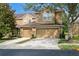 Inviting tan two-story home featuring a two-car garage and well-maintained landscaping at 18939 Duquesne Dr, Tampa, FL 33647