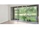 Screened patio view showcasing sliding glass doors, garden plants, and a serene view of the lake at 18939 Duquesne Dr, Tampa, FL 33647