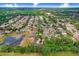 Wide aerial shot of home in quiet neighborhood near community pond and surrounded by trees at 1934 Samantha Ln, Valrico, FL 33594