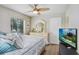 Bright bedroom features a ceiling fan, dresser with decor, and a modern television at 1934 Samantha Ln, Valrico, FL 33594