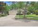 Home exterior with a well-manicured lawn, mature trees, and a concrete driveway leading to an attached garage at 1934 Samantha Ln, Valrico, FL 33594