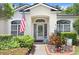 Charming front entrance with an American flag, manicured shrubs, and a decorative front door at 1934 Samantha Ln, Valrico, FL 33594