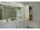 Bright bathroom boasts double sinks, marble countertops, and a built-in linen closet at 1961 Dunbrody Ct, Dunedin, FL 34698