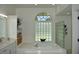 Clean bathroom showcases an oval soaking tub, marble countertops, and a glass block window at 1961 Dunbrody Ct, Dunedin, FL 34698