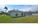 Charming home exterior with a lush lawn and screened-in pool area, ideal for Florida living at 1961 Dunbrody Ct, Dunedin, FL 34698