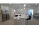 Modern kitchen with stainless steel appliances, bar seating, and white cabinetry at 1961 Dunbrody Ct, Dunedin, FL 34698