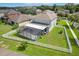 An aerial view of the home, showcasing a large lawn, fenced-in yard, and screened patio enclosure at 20102 Oakflower Ave, Tampa, FL 33647