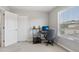 Minimalist bedroom features neutral carpet, a workstation, a closet, and a window overlooking a tree at 20102 Oakflower Ave, Tampa, FL 33647