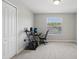 Minimalist bedroom features neutral carpet, a workstation, a closet, and a window overlooking a tree at 20102 Oakflower Ave, Tampa, FL 33647