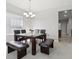 Elegant dining room features a modern chandelier, dark table and bench seating near a window at 20102 Oakflower Ave, Tampa, FL 33647