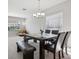 Bright dining room with a modern chandelier, large window, and sleek table with bench seating at 20102 Oakflower Ave, Tampa, FL 33647