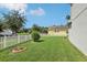 Well-maintained front yard with lush green grass and manicured shrubs, complemented by a white picket fence at 20102 Oakflower Ave, Tampa, FL 33647