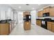 Bright kitchen with granite countertops, wood cabinets, center island, and modern appliances at 20102 Oakflower Ave, Tampa, FL 33647