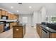 Open kitchen featuring granite counters, wood cabinets, a center island, and stainless appliances at 20102 Oakflower Ave, Tampa, FL 33647