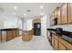 Well-lit kitchen with wood cabinets, black appliances, and granite countertops offers style and functionality at 20102 Oakflower Ave, Tampa, FL 33647