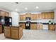 Spacious kitchen features granite countertops, wooden cabinets, and modern black appliances at 20102 Oakflower Ave, Tampa, FL 33647
